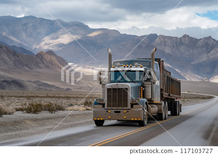 Heavy-duty semi truck drives on a secluded highway with dramatic mountain scenery 117103727