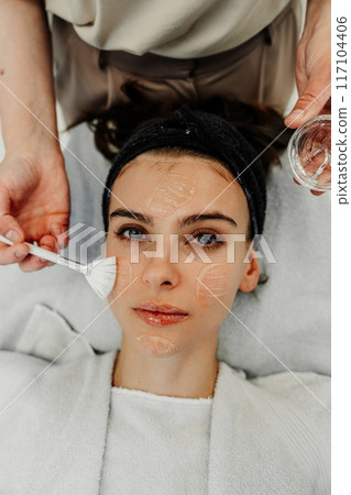 Skincare Treatment Session in a Cozy Spa During Late Afternoon With Relaxed Client Receiving Facial Care 117104406