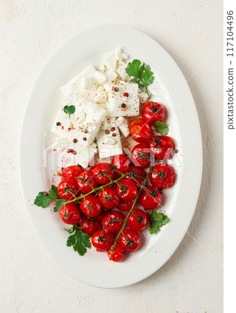 baked cherry tomatoes , with cheese, and spices, on a white plate, homemade, no people, 117104496