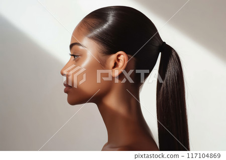 Side profile of a woman's elegant sleek ponytail under soft lighting Side profile of a woman's elegant sleek ponytail under soft lighting 117104869