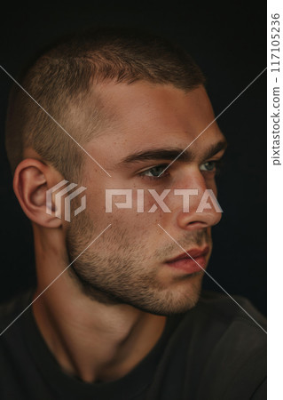 Close-up photo showcasing a man's buzz cut against a dark background 117105236