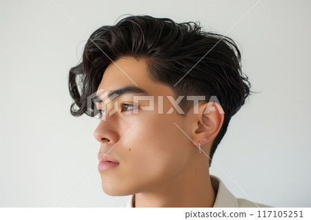 Close-up of a young man showcasing a modern side part haircut against a white background 117105251