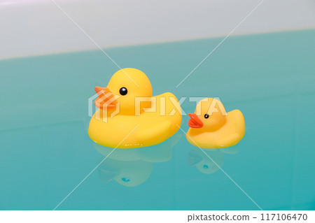 Yellow duck toy floating in the bathtub 117106470