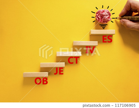 Objectives symbol. Concept word Objectives on beautiful wooden blocks. Beautiful yellow background. Businessman hand. Beautiful light bulb icon. Business objectives concept. Copy space. 117106905