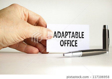 Adaptable office symbol. Concept words Adaptable office on beautiful white paper. Beautiful white background. Businessman hand. Business Adaptable office concept. Copy space. 117106958