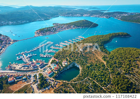 Aerial view of sea landscape with coastal town and yachts. Touristic city for summer vacation among Islands in Adriatic sea. Panoramic view of marina Frapa and Dragon Eye lake in Rogoznica, Croatia Aerial view of sea landscape with coastal town and yachts. Touristic city for summer vacation among Islands in Adriatic sea. Panoramic view of marina Frapa and Dragon Eye lake in Rogoznica, Croatia 117108422