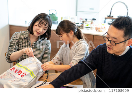 一家人將防災物資裝入應急包 117108609