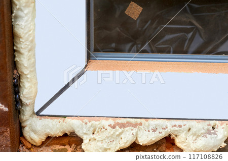 Construction foam.Installation of a metal plastic window in a brick wall 117108826