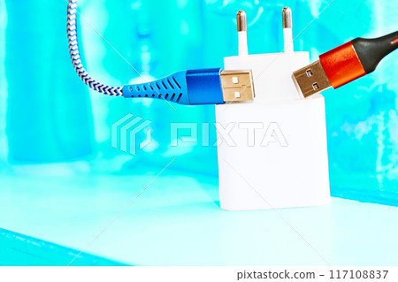 Charger,two red blue usb cables on bright grunge azure surface Charger,two red blue usb cables on bright grunge azure surface 117108837