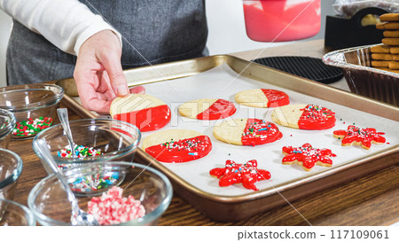 Crafting star-shaped holiday cookies dipped in chocolate and sprinkled with variety of toppings. 117109061
