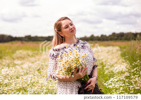 Beautiful woman in the field with flowers. Beautiful woman in the field with flowers. 117109579