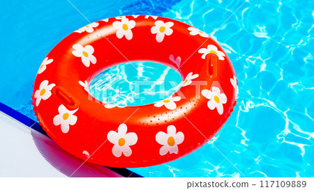 Red inflatable ring with a daisy pattern in the pool 117109889