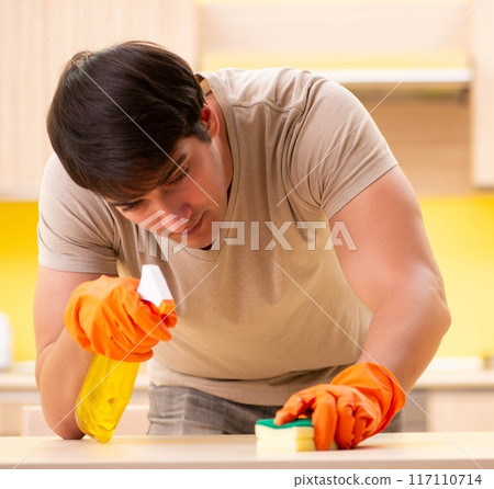 Single man cleaning kitchen at home Single man cleaning kitchen at home 117110714
