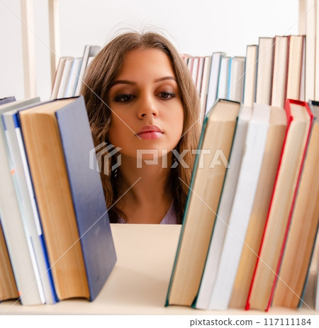 Young female student preparing for exams at library Young female student preparing for exams at library 117111184