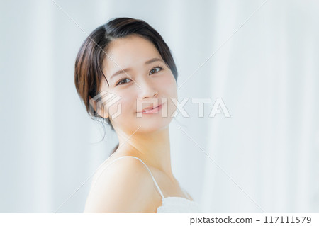 一位年輕女子感到皮膚濕潤 一位年輕女子感到皮膚濕潤 117111579