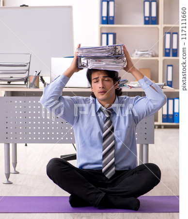 Young handsome male employee doing exercises in the office Young handsome male employee doing exercises in the office 117111660