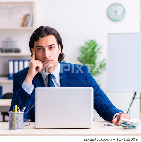 Young businessman sitting and working in the office 117112309