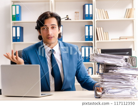 Young handsome busy employee sitting in office 117112350
