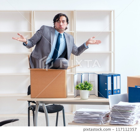 Young man employee with boxes in the office Young man employee with boxes in the office 117112357