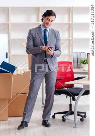 Young man employee with boxes in the office Young man employee with boxes in the office 117112384