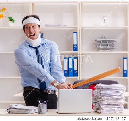 Young injured male employee working in the office 117112417