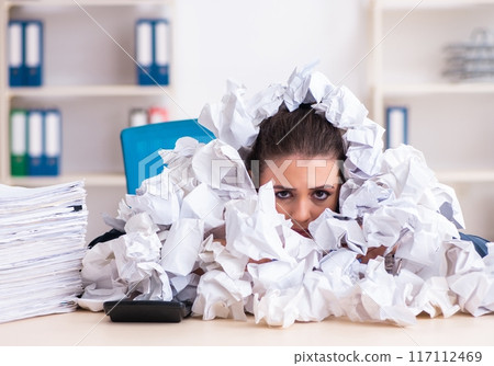 Businesswoman rejecting new ideas with lots of papers 117112469
