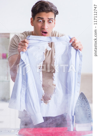 Inattentive husband burning clothing while ironing Inattentive husband burning clothing while ironing 117112747