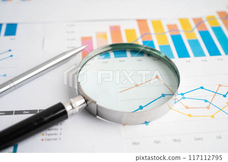 Magnifying glass on graph. Finance business and trading. 117112795