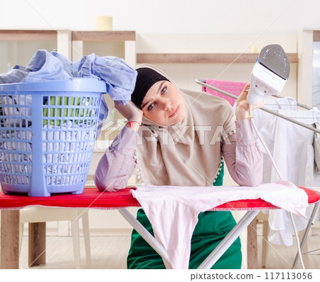 Woman in hijab doing clothing ironing at home 117113056