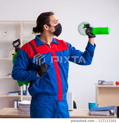 Young male contractor disinfecting office 117113103