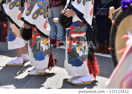 日本岐阜縣高山市,春季高山祭,人們身穿白色服裝,上面印有鳥的圖案,敲響名為「鬥雞樂」的小鐘。 日本岐阜縣高山市,春季高山祭,人們身穿白色服裝,上面印有鳥的圖案,敲響名為「鬥雞樂」的小鐘。 117113412