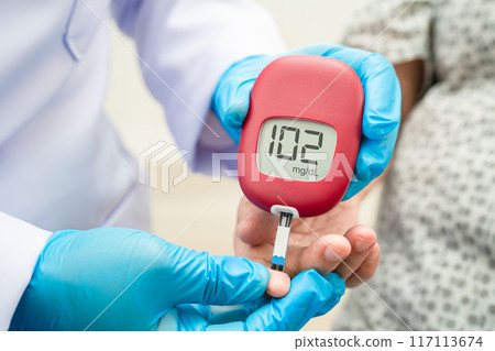 Doctor check diabetes from finger blood sugar level with finger lancet. 117113674