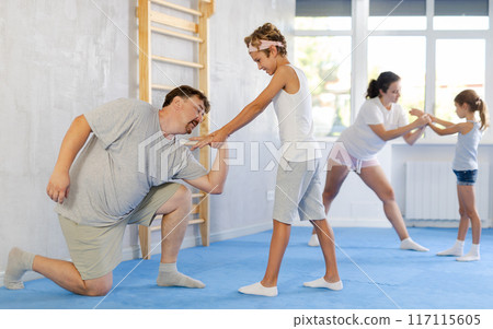 Father and son training self-defense techniques 117115605
