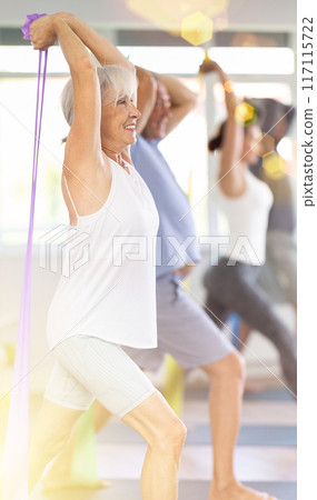 Group Pilates classes for seniors - using resistance bands and expander to stretch entire body Group Pilates classes for seniors - using resistance bands and expander to stretch entire body 117115722