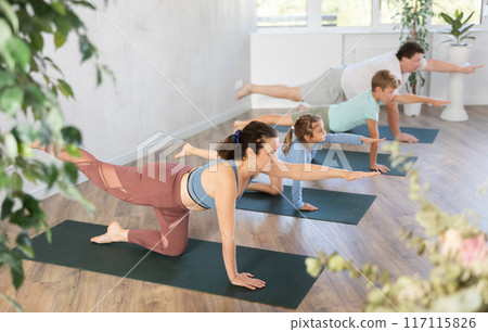 Family with exercising during yoga class at sport gym 117115826