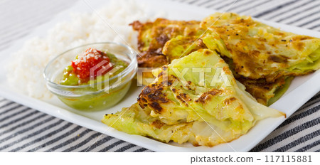 Leaves of cabbage in batter with rice and green sauce on a plate Leaves of cabbage in batter with rice and green sauce on a plate 117115881