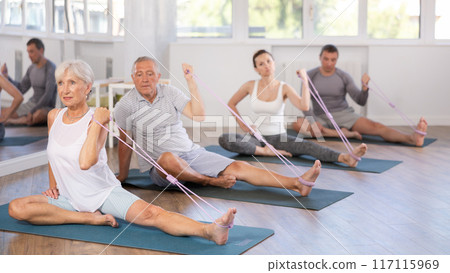 Elderly woman exercising with pilates loop 117115969