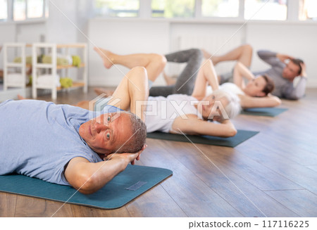 Pensioners doing fitness in group classes - doing exercises for abdominal muscles Pensioners doing fitness in group classes - doing exercises for abdominal muscles 117116225