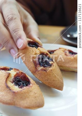 Treat yourself to some delicious freshly baked madeleines elegantly served on a white plate Treat yourself to some delicious freshly baked madeleines elegantly served on a white plate 117116621