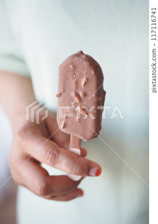 young women hand holding a chocolate flavor ice cream young women hand holding a chocolate flavor ice cream 117116741
