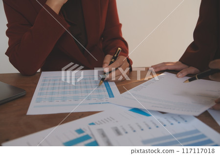 Group of confident business people point to graphs and charts to analyze market data, balance sheet, account, net profit to plan new sales strategies to increase production capacity. Group of confident business people point to graphs and charts to analyze market data, balance sheet, account, net profit to plan new sales strategies to increase production capacity. 117117018