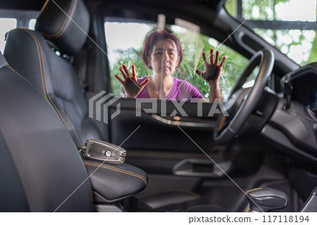 Senior asian woman forgot her key inside locked car. 117118194