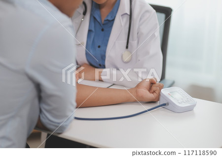 The doctor woman hand use the pulse meter to measure the pressure of the patient, medical checkup concept. The doctor woman hand use the pulse meter to measure the pressure of the patient, medical checkup concept. 117118590