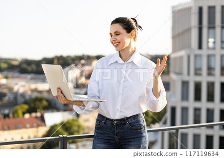 Remote business meeting on rooftop with happy woman using laptop Remote business meeting on rooftop with happy woman using laptop 117119634