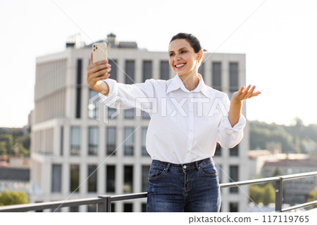 Woman taking selfie on rooftop in casual attire 117119765