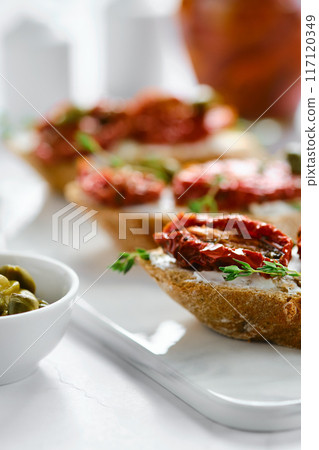 Close-up view of bruschetta with sun-dried tomatoes and capers 117120349
