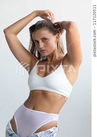 Beautiful blonde in white lingerie posing on white background Beautiful blonde in white lingerie posing on white background 117120511