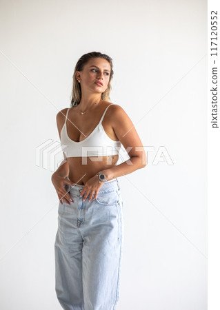 Beautiful blonde in white lingerie posing on white background 117120552