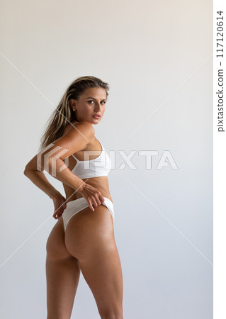 Beautiful blonde posing in lingerie in studio on white background 117120614