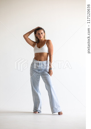 Beautiful blonde in white lingerie posing on white background Beautiful blonde in white lingerie posing on white background 117120636